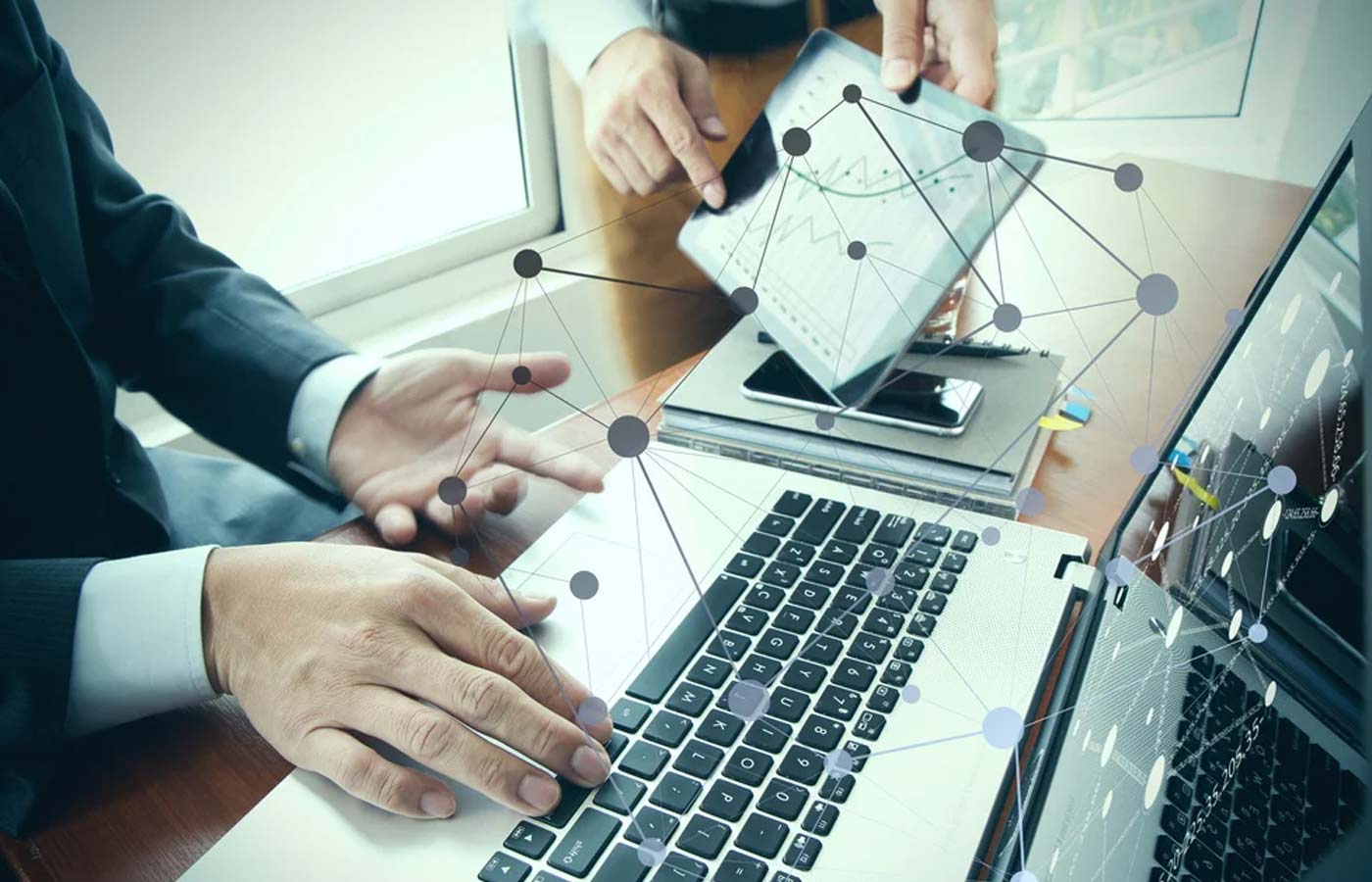 business documents on office table with smart phone and digital tablet and stylus and two colleagues discussing data in the background-1