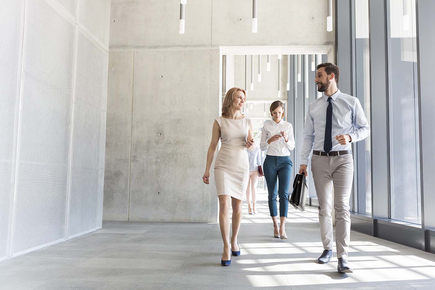 Uomo e donna d'affari che camminano lungo un corridoio